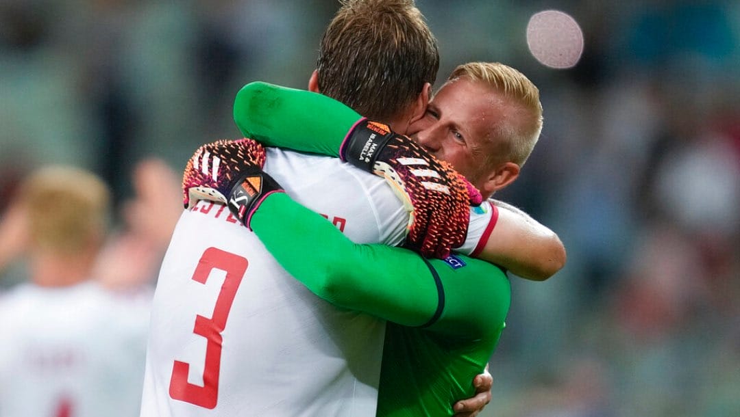 Denmark's goalkeeper Kasper Schmeichel, right, hugs Jannik Vestergaard at the end of the Euro 2020 soccer championship quarterfinal match.