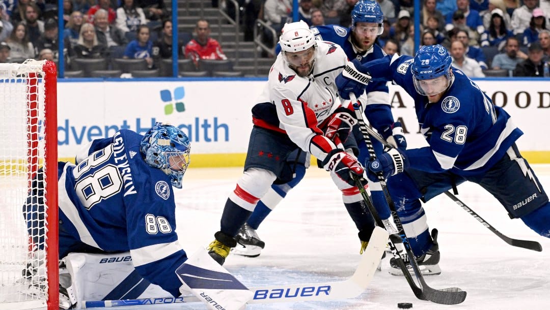 Washington Capitals left wing Alex Ovechkin (8) and Tampa Bay Lightning defenseman Ian Cole (28) battle for the puck in front of Lightning goaltender Andrei Vasilevskiy (88) during the third period of an NHL hockey game Sunday, Nov. 13, 2022, in Tampa, Fla.