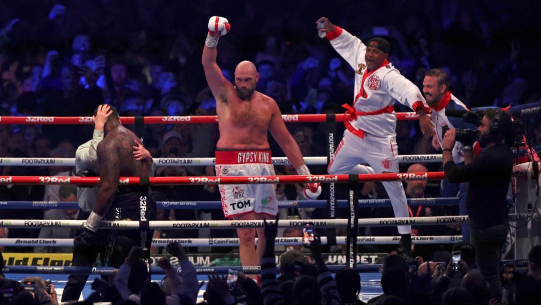 Britain's Tyson Fury, center, celebrates after beating Britain's Dillian Whyte during their WBC heavyweight title boxing fight.