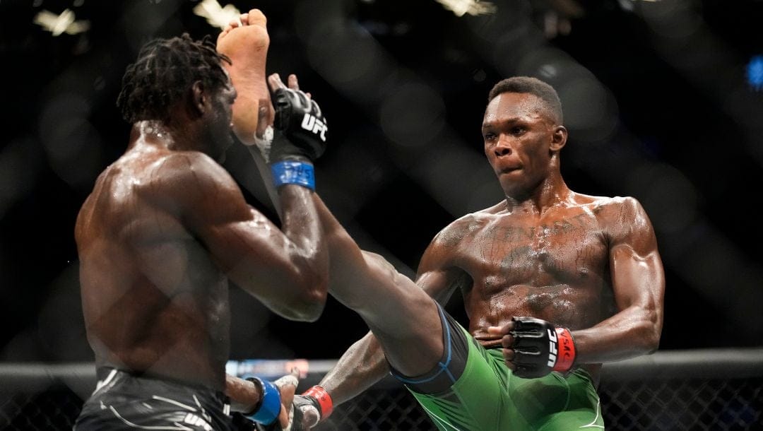 Israel Adesanya, right, kicks Jared Cannonier in a middleweight title bout during the UFC 276 mixed martial arts event.