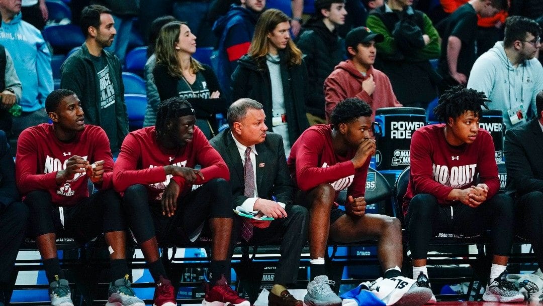 New Mexico State players watch play against Arkansas from the bench during the second half of a college basketball game in the second round of the NCAA men's tournament Saturday, March 19, 2022, in Buffalo, N.Y.