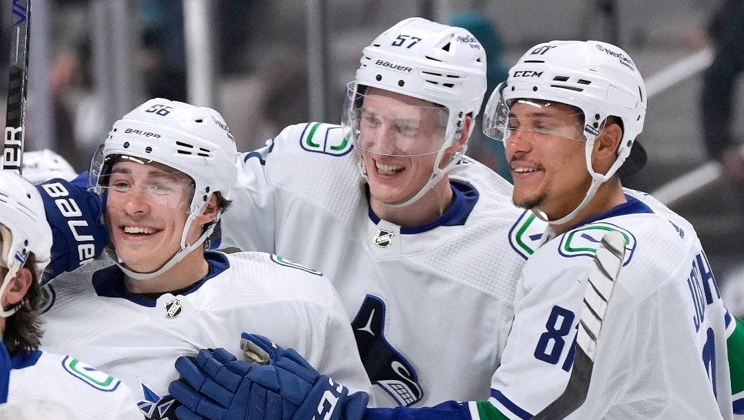Vancouver Canucks left wing Andrei Kuzmenko, left, celebrates with Tyler Myers (57) and Dakota Joshua (81) after scoring the winning goal during overtime against the San Jose Sharks in an NHL hockey game Sunday, Nov. 27, 2022, in San Jose, Calif. Vancouver won 4-3 in overtime.