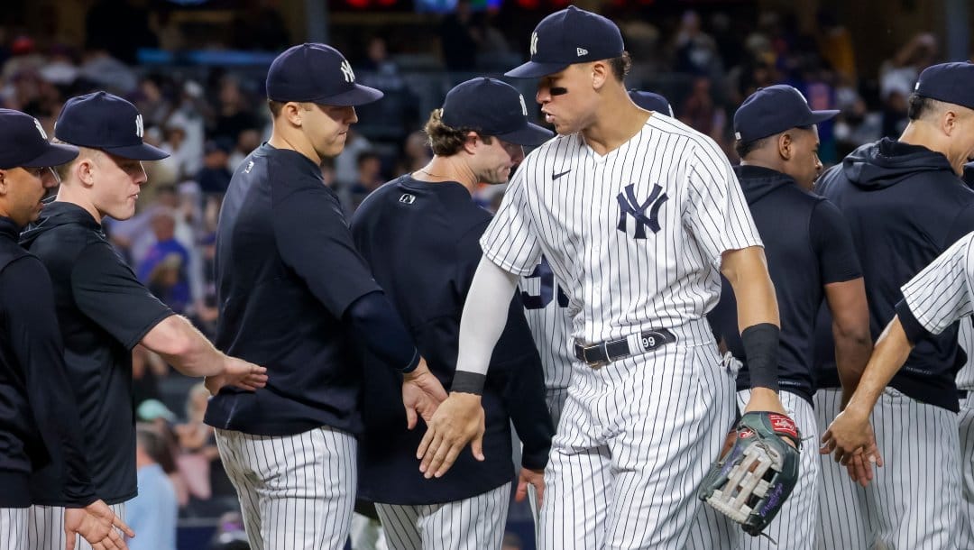 New York Yankees' Aaron Judge celebrates a win with teammate after a baseball game against the New York Mets, Monday, Aug. 22, 2022, in New York.