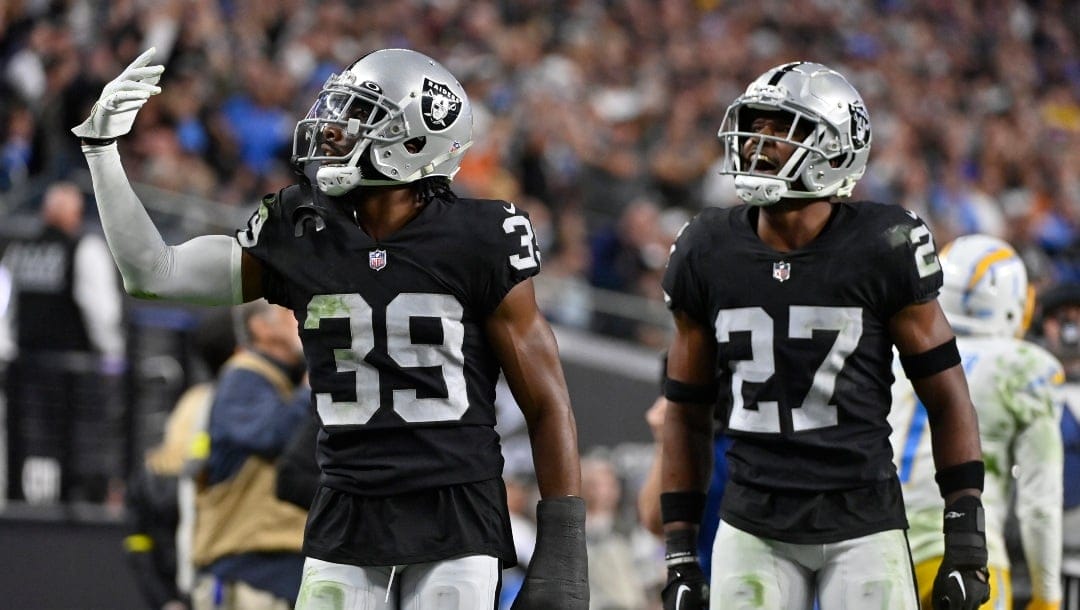 Las Vegas Raiders cornerback Nate Hobbs (39) celebrates with cornerback Sam Webb (27) after the Los Angeles Chargers turned the ball over on downs during the second half of an NFL football game, Sunday, Dec. 4, 2022, in Las Vegas. The Raiders won 27-20. (AP Photo/David Becker)