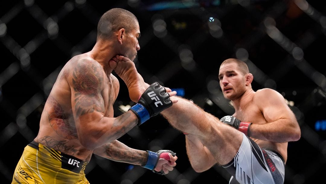 Sean Strickland, right, kicks Alex Pereira in a middleweight bout during the UFC 276 mixed martial arts event Saturday, July 2, 2022.