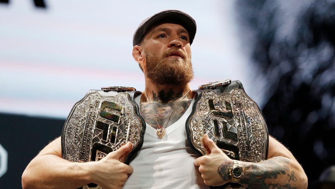 Conor McGregor holds up belts during a news conference for the UFC 229 mixed martial arts bouts Thursday, Oct. 4, 2018.