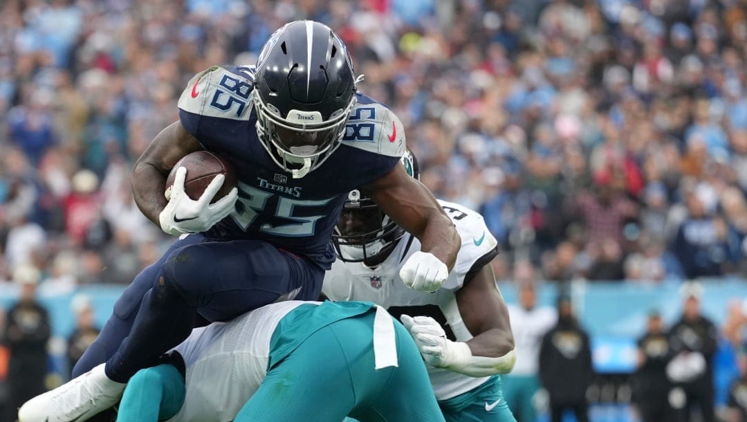 Tennessee Titans tight end Chigoziem Okonkwo (85) leaps over Jacksonville Jaguars safety Rayshawn Jenkins (2) for a touchdown during an NFL football game against the Jacksonville Jaguars, Sunday, Dec. 11, 2022, in Nashville, Tenn. (AP Photo/Peter Joneleit)