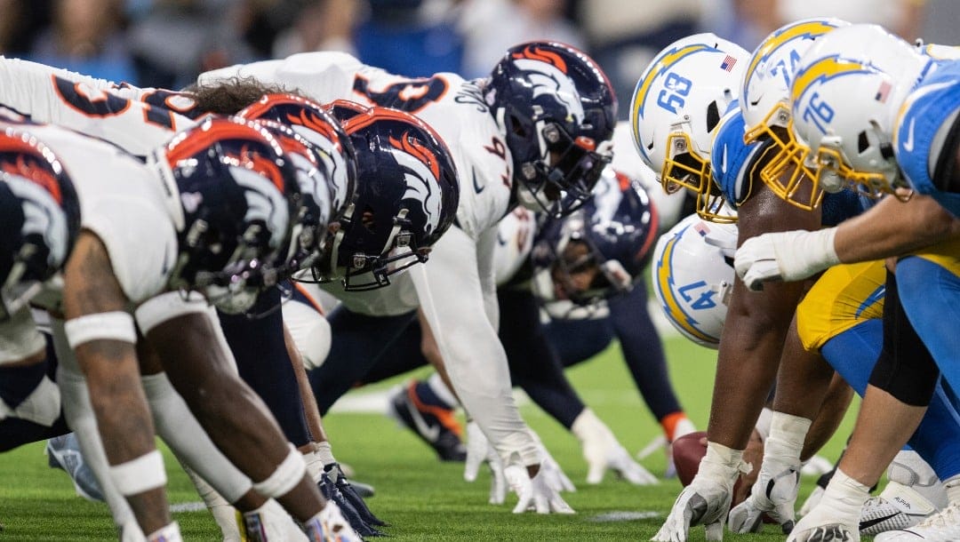 Los Angeles Chargers and Denver Broncos players take their stance during an NFL football game, Monday, Oct. 17, 2022, in Inglewood, Calif. (AP Photo/Kyusung Gong)