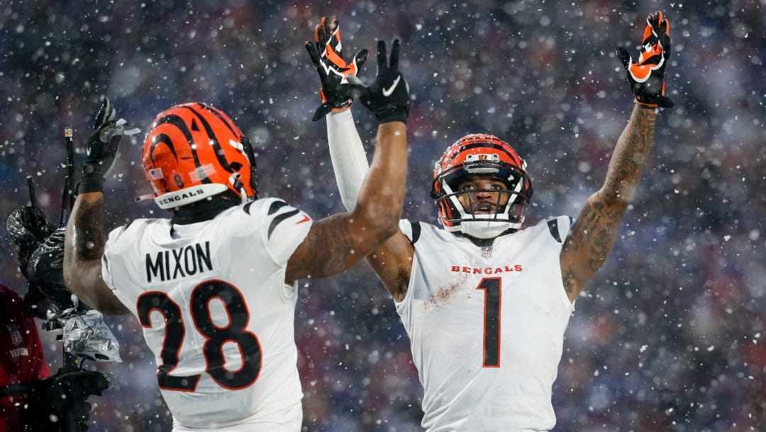 Cincinnati Bengals wide receiver Ja'Marr Chase (1) and Cincinnati Bengals running back Joe Mixon (28) motion for a touchdown against the Buffalo Bills during the third quarter of an NFL division round football game, Sunday, Jan. 22, 2023, in Orchard Park, N.Y. (AP Photo/Joshua Bessex)