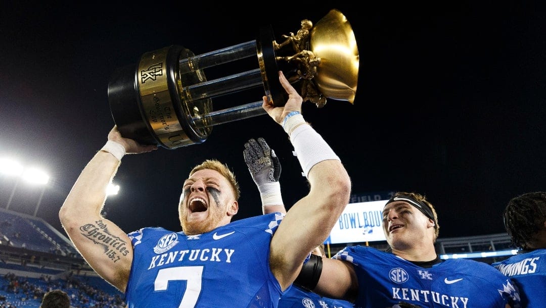 Kentucky quarterback Will Levis (7) holds up the Governor's Cup trophy after his team defeated Louisville in an NCAA college football game in Lexington, Ky., Saturday, Nov. 26, 2022. (AP Photo/Michael Clubb)