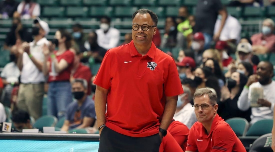 A basketball coach with a red t-shirt with a LU logo printed on it