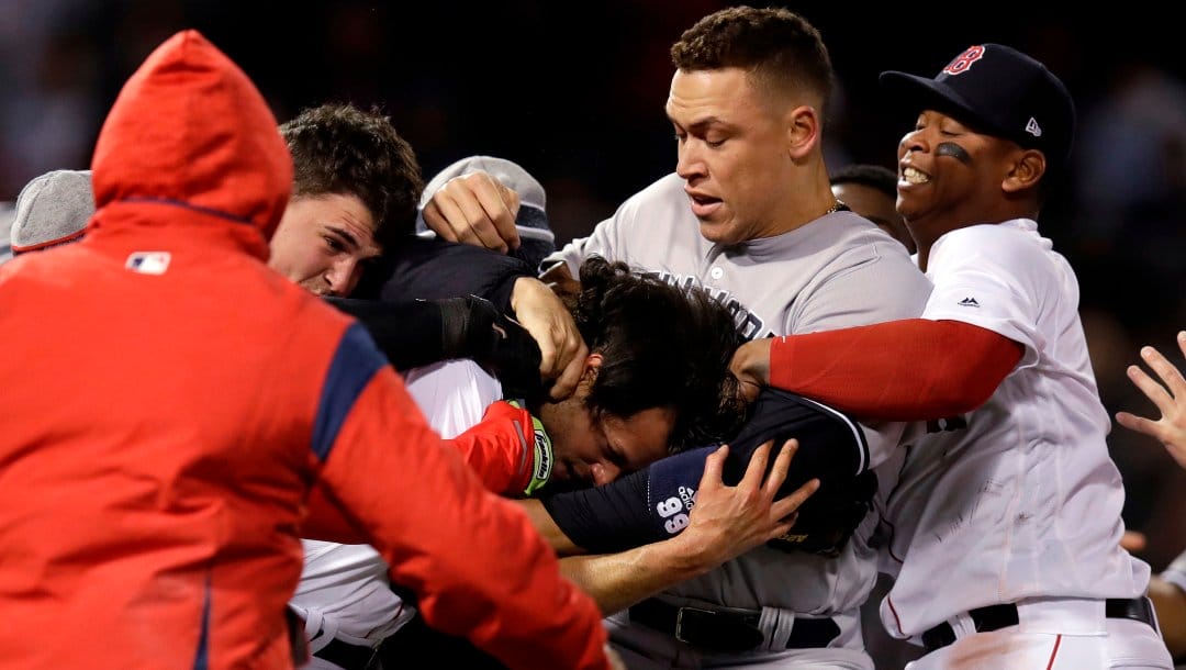 New York Yankees right fielder Aaron Judge puts Boston Red Sox relief pitcher Joe Kelly in a headlock as they fight during the seventh inning of a baseball game at Fenway Park in Boston, Wednesday, April 11, 2018. At right is Boston Red Sox third baseman Rafael Devers.