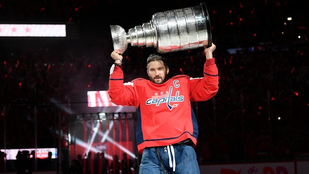 Washington Capitals left wing Alex Ovechkin (8), of Russia, carries the Stanley Cup during introductions and a banner raising ceremony before an NHL hockey game against the Boston Bruins, Wednesday, Oct. 3, 2018, in Washington.