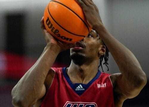 A player in Burgundy and Blue uniform preparing to shoot for the hoop