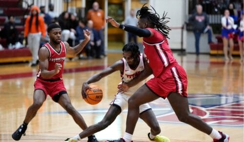 Two Youngstate Penguins players defending an opposition player dribbling an NBA game ball