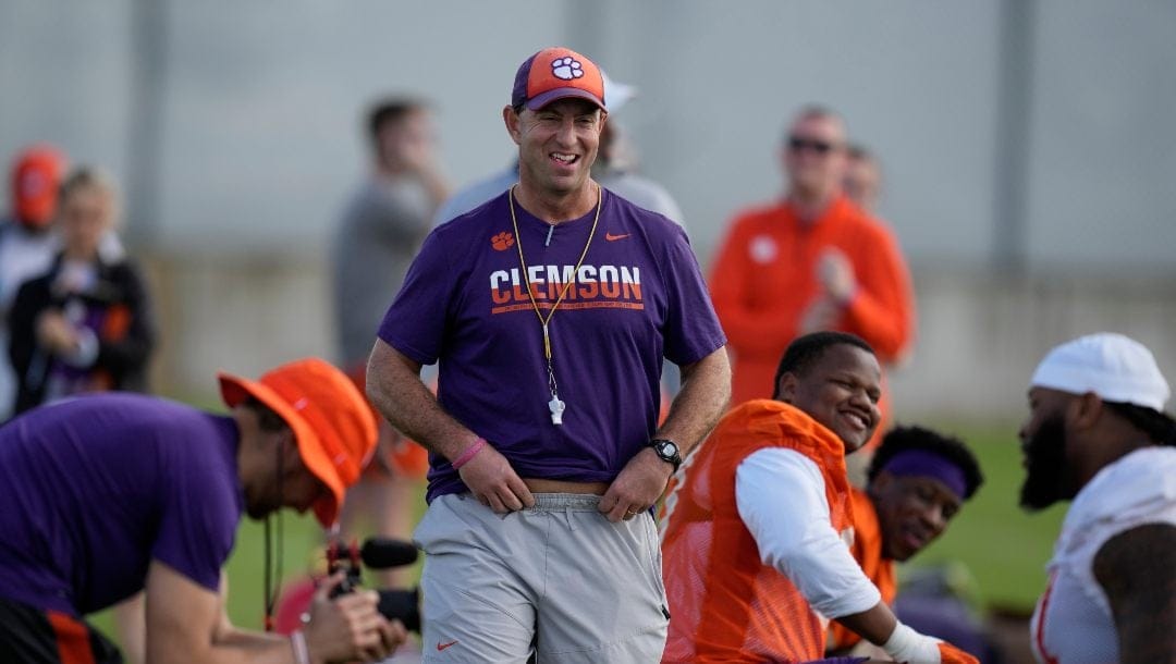 Clemson Tigers head coach Dabo Swinney, center, jokes around with his players as they stretch, during a practice session ahead of the 2022 Orange Bowl, Wednesday, Dec. 28, 2022, in Fort Lauderdale, Fla. Clemson will face the Tennessee Volunteers in the Orange Bowl on Friday, Dec. 30.