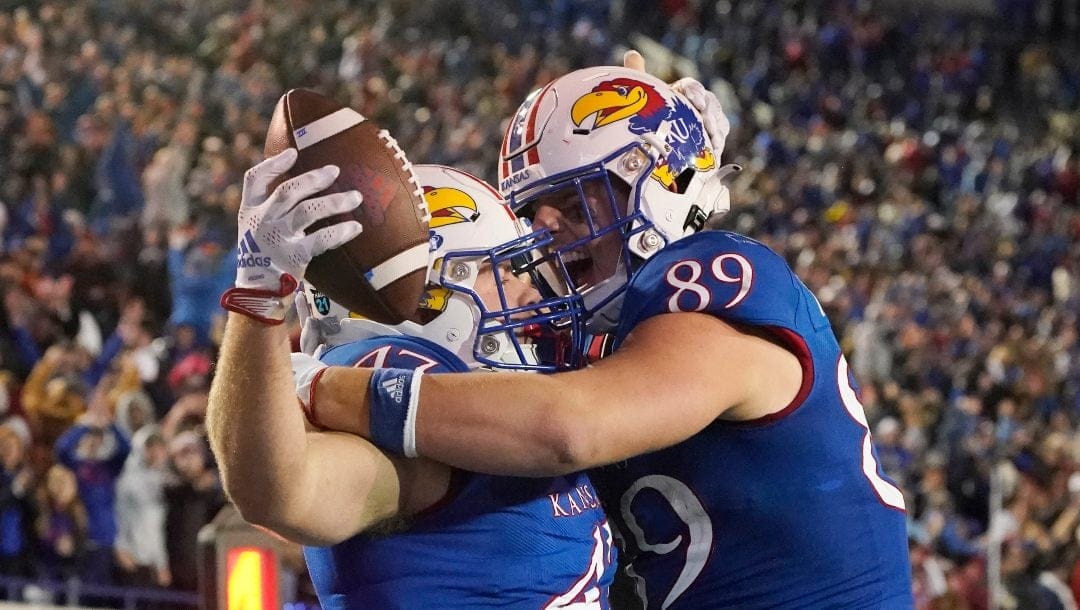 Kansas tight end Jared Casey (47) left, is congratulated by teammate tight end Mason Fairchild (89) following his scoring a two-yard overtime touchdown during the second half of the Liberty Bowl NCAA college football game, Wednesday, Dec. 28, 2022, in Memphis, Tenn. Arkansas won in three overtimes, 55-53.