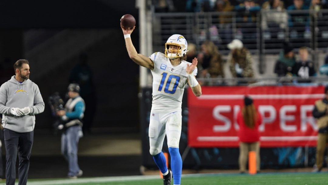 Los Angeles Chargers quarterback Justin Herbert (10) warms up near the sideline during an NFL wild-card football game against the Jacksonville Jaguars, Saturday, Jan. 14, 2023, in Jacksonville, Fla. The Jaguars defeated the Chargers 31-30.
