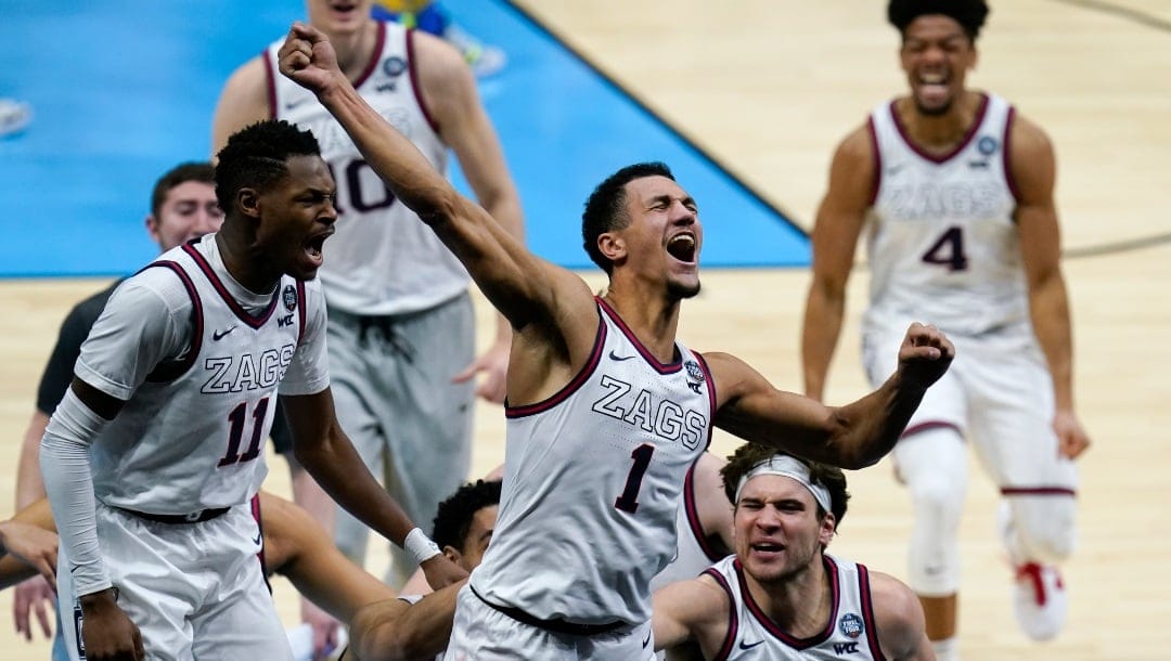 FILE - Gonzaga guard Jalen Suggs (1) celebrates making the game winning basket against UCLA during overtime in a men's Final Four NCAA college basketball tournament semifinal game, Saturday, April 3, 2021, at Lucas Oil Stadium in Indianapolis. Gonzaga won 93-90. A few years ago, with the football-playing Mountain West Conference perennially knocking on the door, Gonzaga cut a deal with the WCC: It would stay in the hoops-only league if, instead of splitting things evenly, the conference would give the Zags a bigger share of its NCAA tournament proceeds based on how they performed in March. (AP Photo/Michael Conroy, File)