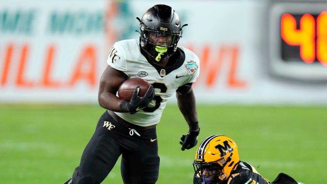 Wake Forest running back Justice Ellison (6) slips by Missouri defensive lineman Arden Walker on a run during the first half of the Gasparilla Bowl NCAA college football game Friday, Dec. 23, 2022, in Tampa, Fla. (AP Photo/Chris O'Meara)