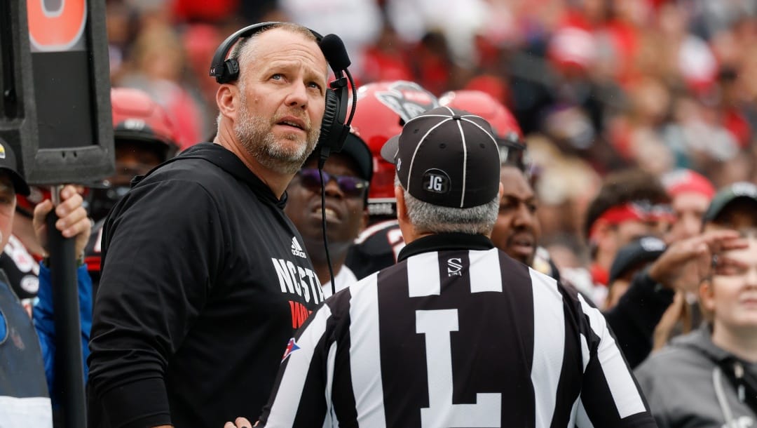 North Carolina State head coach Dave Doeren argues a call with line judge Matt Dornan during the first half of the Duke's Mayo Bowl NCAA college football game against Maryland in Charlotte, N.C., Friday, Dec. 30, 2022. (AP Photo/Nell Redmond)