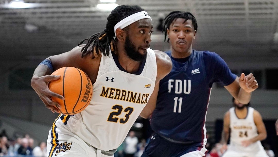 Merrimack forward Ziggy Reid (23) drives to the basket against Fairleigh Dickinson forward Sean Moore (11) during the second half of Northeast Conference men's NCAA college basketball championship game, Tuesday, March 7, 2023, in North Andover, Mass. (AP Photo/Charles Krupa)