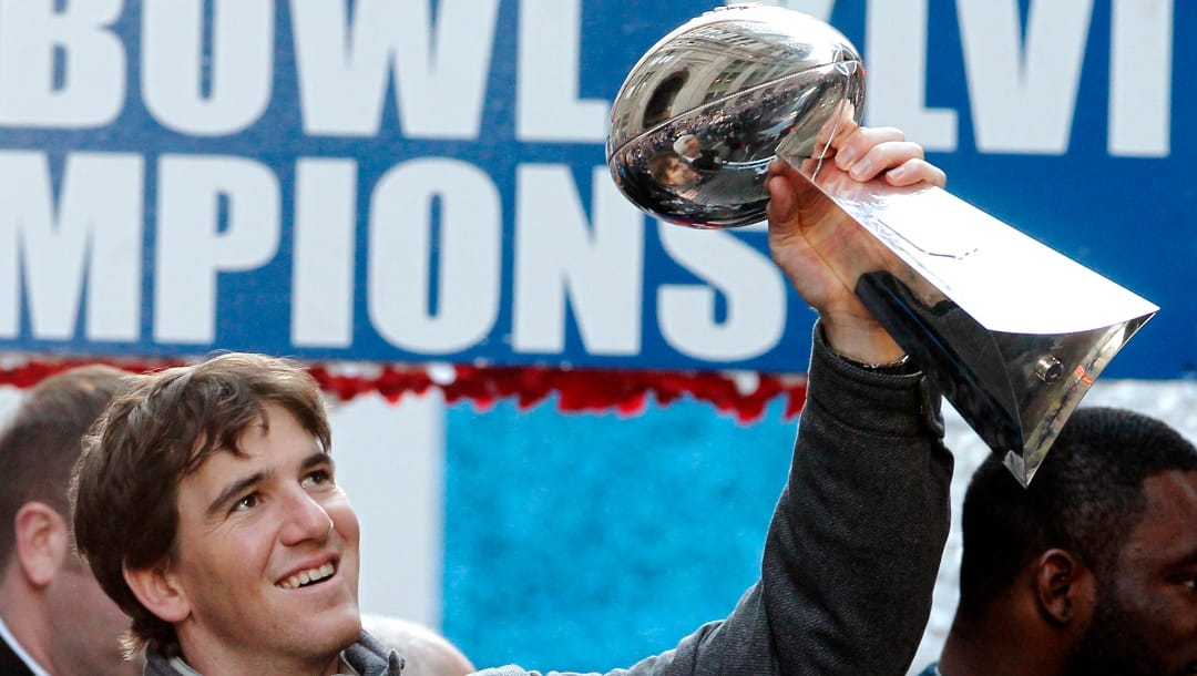 Then-New York Giants quarterback Eli Manning holds up the Vince Lombardi Trophy