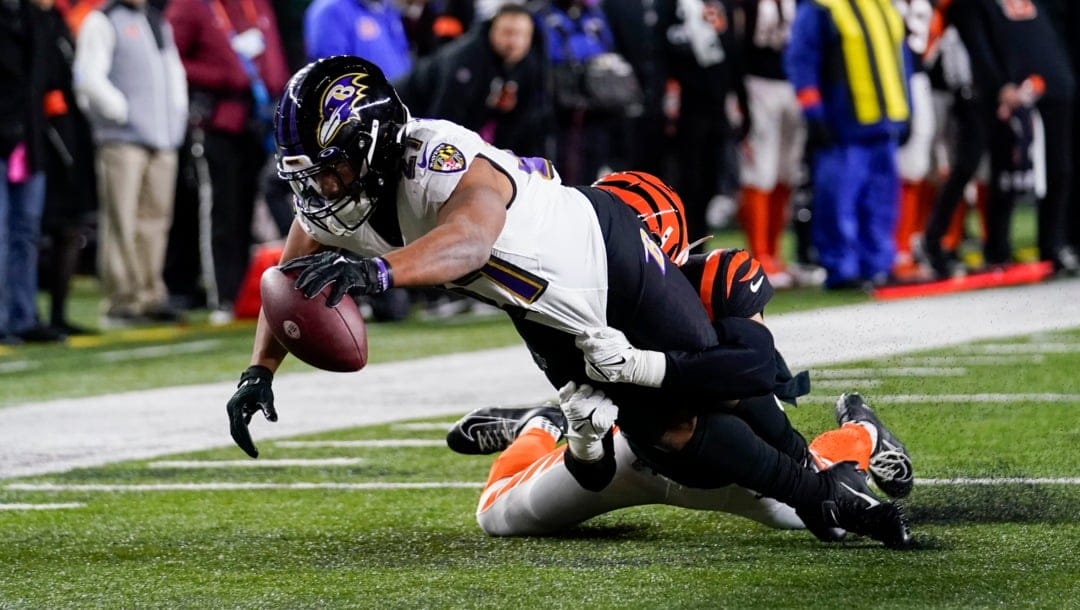 Baltimore Ravens running back J.K. Dobbins (27) scores a touchdown while being chased by Cincinnati Bengals linebacker Markus Bailey (51) during a wild-card playoff NFL football game, Monday, Jan. 16, 2023, in Cincinnati. (AP Photo/Jeff Dean)