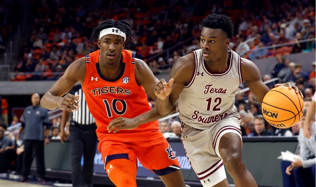No 12 from Texas Southern dribbling the NBA game ball with an opponent behind him