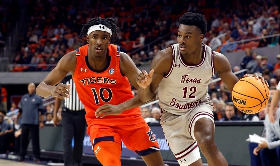 No 12 from Texas Southern dribbling the NBA game ball with an opponent behind him
