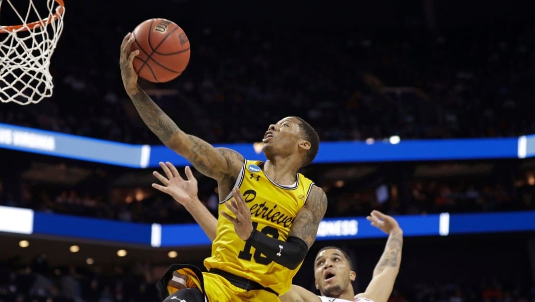 UMBC's Jairus Lyles (10) drives past Virginia's Isaiah Wilkins (21) and Kyle Guy (5) during the second half of a first-round game in the NCAA men's college basketball tournament in Charlotte, N.C., Friday, March 16, 2018. (AP Photo/Gerry Broome)