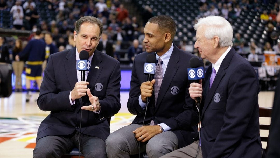 In this March 12, 2016 file photo, CBS broadcasters, left to right, play-by-play commentator Jim Nantz, along with game analyses Grant Hill and Bill Raftery work before NCAA college basketball game during the semifinals of the Big Ten Conference tournament in Indianapolis.