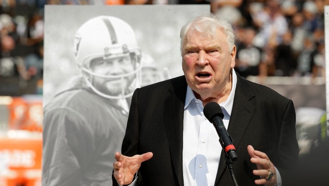 Former Oakland Raiders head coach John Madden speaks about former quarterback Ken Stabler, pictured at rear, during a ceremony honoring Stabler at halftime of an NFL football game between the Raiders and the Cincinnati Bengals in Oakland, Calif., on Sept. 13, 2015. The NFL is making that a lasting tribute by honoring the late broadcaster by launching the “John Madden Thanksgiving Celebration” to begin on the first Thanksgiving following his death last December.