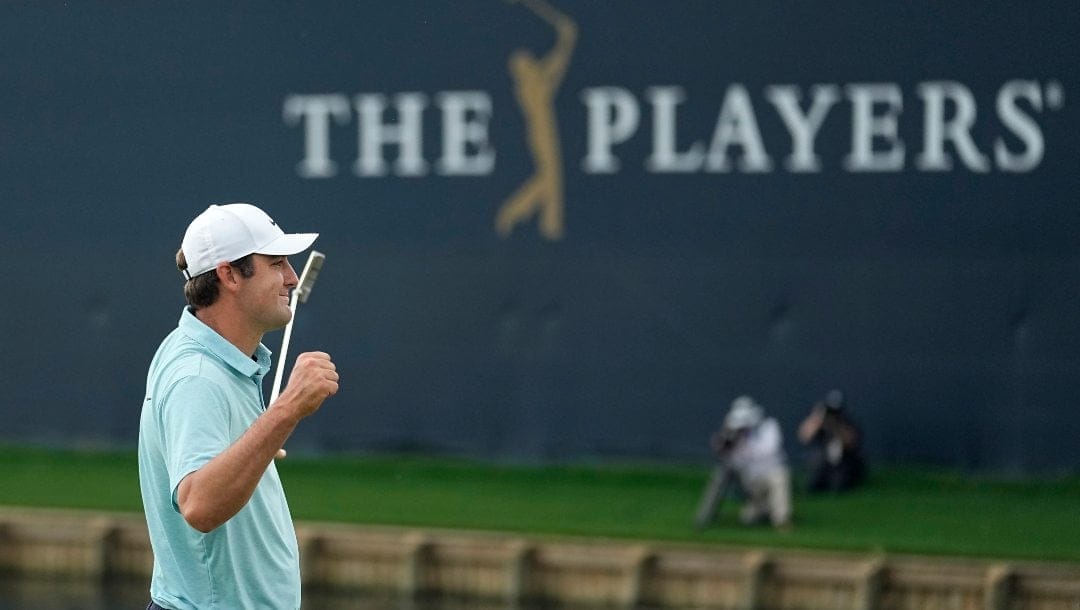 Scottie Scheffler celebrates after putting on the 18th green during the final round of The Players Championship golf tournament, which Scheffler won, Sunday, March 12, 2023, in Ponte Vedra Beach, Fla.