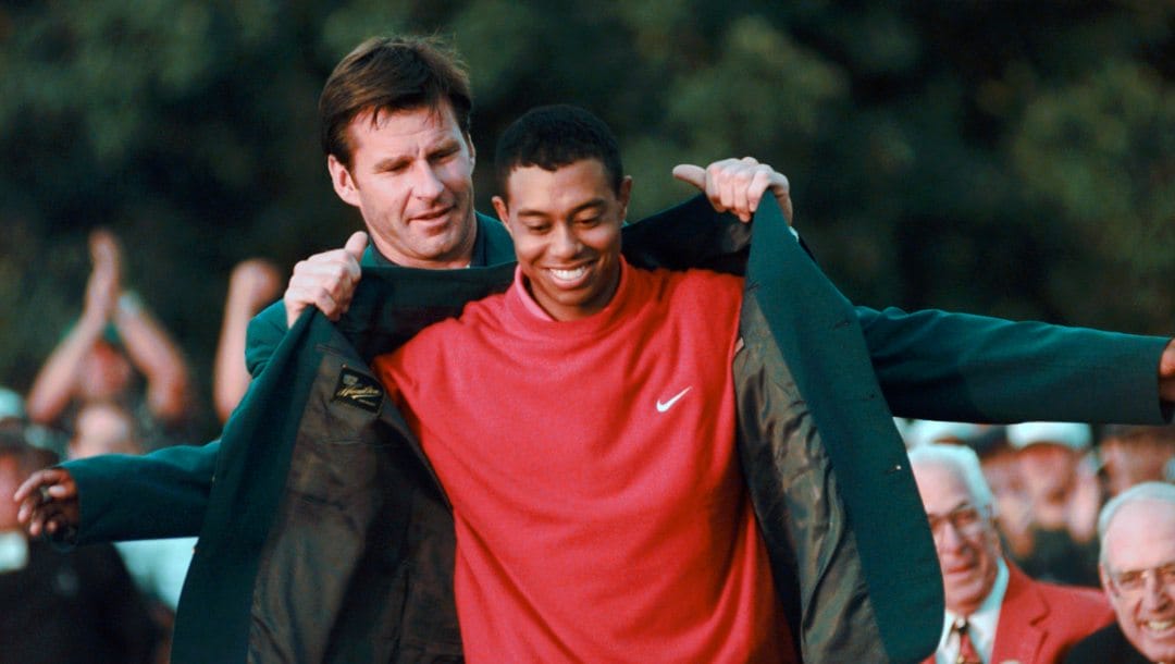Masters champion Tiger Woods receives his Green Jacket from last year's winner Nick Faldo, left, at the Augusta National Golf Club in Augusta, Ga.