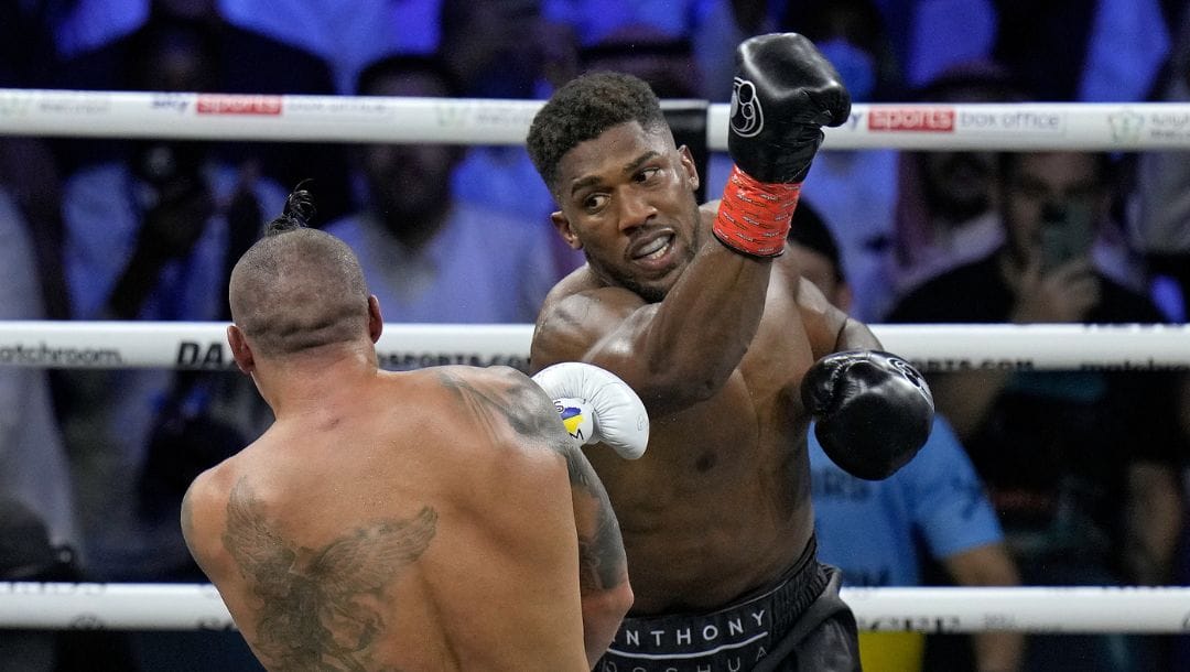 Britain's Anthony Joshua, right, launches a blow at Ukraine's Oleksandr Usyk during their world heavyweight title fight.