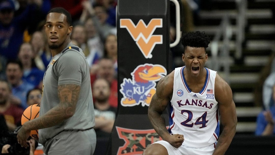 Kansas forward K.J. Adams Jr. (24) celebrates after making a basket during the first half of an NCAA college basketball game against West Virginia in the second round of the Big 12 Conference tournament Thursday, March 9, 2023, in Kansas City, Mo. (AP Photo/Charlie Riedel)