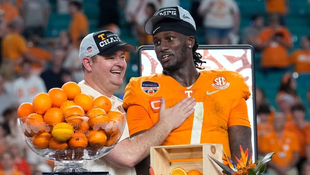 Tennessee coach Josh Heupel, left, and quarterback Joe Milton III (7) stand behind the trophy after the team's win over Clemson in the Orange Bowl NCAA college football game Saturday, Dec. 31, 2022, in Miami Gardens, Fla. (AP Photo/Lynne Sladky