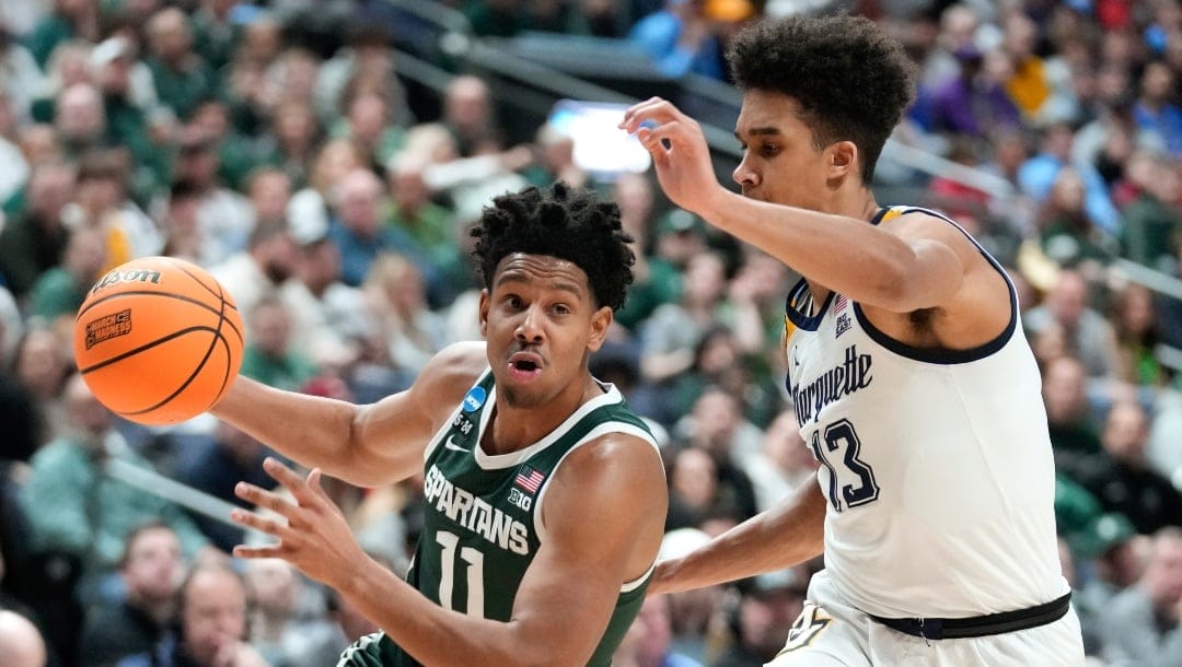 Michigan State guard A.J. Hoggard (11) drives on Marquette forward Oso Ighodaro (13) in the first half of a second-round men's college basketball game in the NCAA Tournament Sunday, March 19, 2023, in Columbus, Ohio.