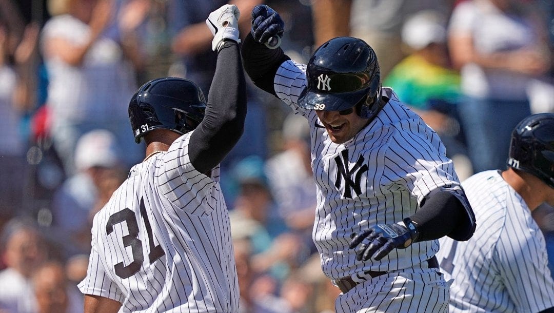 New York Yankees' Jose Trevino (39) celebrates with Aaron Hicks (31) after hitting a grand slam against the Atlanta Braves during a spring training baseball game Sunday, Feb. 26, 2023, in Tampa, Fla.