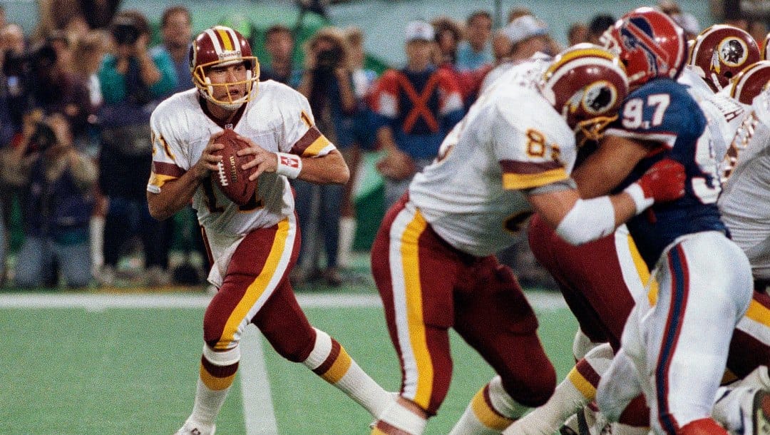 FILE - In this Jan. 26, 1992, file photo, Washington Redskins' Don Warren (85) keeps Buffalo Bills Cornelius Bennet (97) away from Redskins quarterback Mark Rypien during NFL football's Super Bowl XXVI in Minneapolis. Rypien passed for 292 yards and two touchdowns to lead the Redskins to their third Super Bowl title.