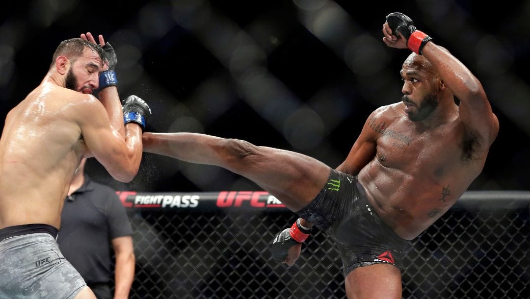 File - In this Feb. 8, 2020, file photo, Jon Jones, right, kicks Dominick Reyes during a light heavyweight mixed martial arts bout.