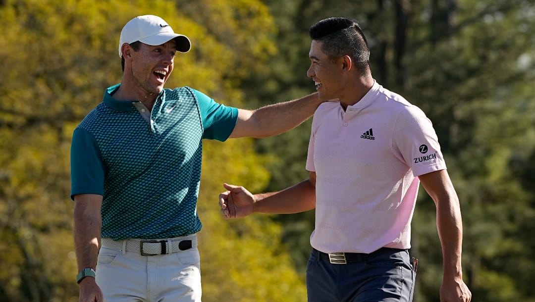 Rory McIlroy, of Northern Ireland, talks to Collin Morikawa after they both holed out from the bunker for a birdie during the final round at the Masters golf tournament on Sunday, April 10, 2022, in Augusta, Ga.
