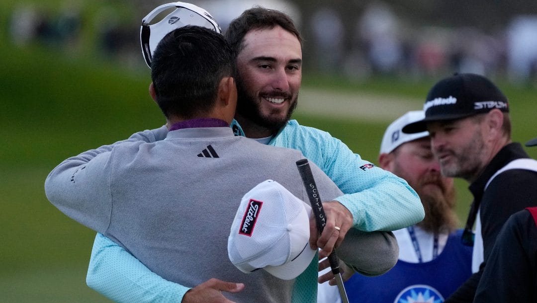 Max Homa, center, embraces Collin Morikawa after making his putt for birdie on the 18th hole to win the Farmers Insurance Open golf tournament, Saturday, Jan. 28, 2023, in San Diego.