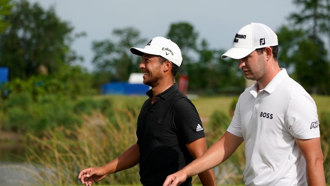 Xander Schauffele and Patrick Cantlay approach the 18th green during the final round of the PGA Zurich Classic golf tournament at TPC Louisiana in Avondale, La., Sunday, April 24, 2022.