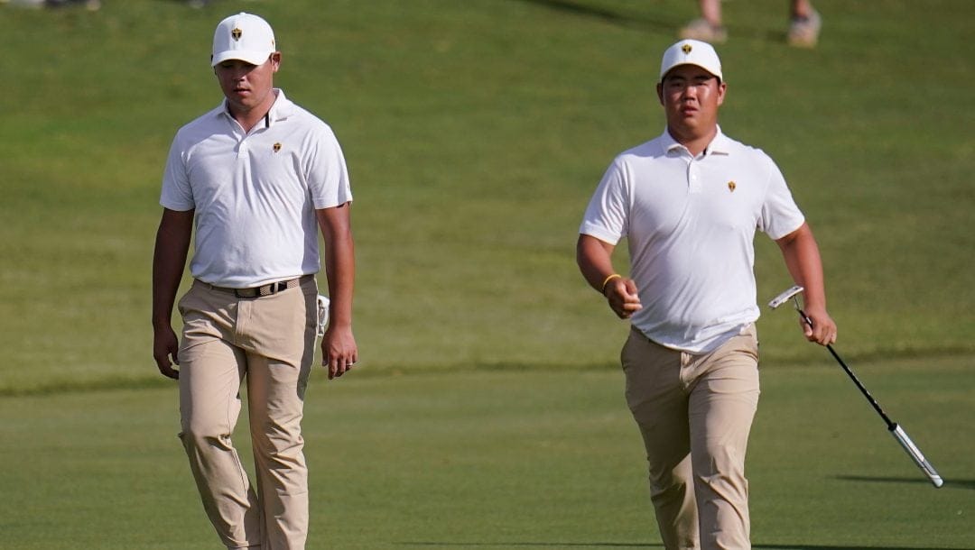 Si Woo Kim, of South Korea, and Tom Kim, of South Korea, walk toward the 15th green during their fourball match at the Presidents Cup golf tournament at the Quail Hollow Club, Saturday, Sept. 24, 2022, in Charlotte, N.C.