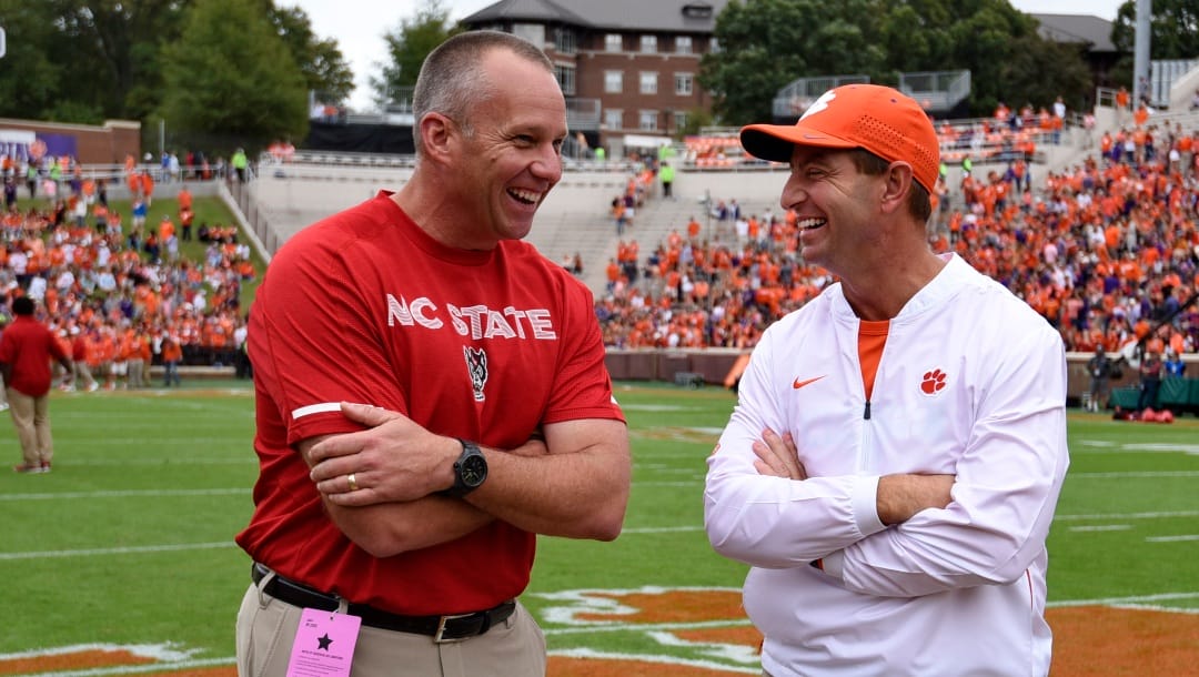 Clemson head coach Dabo Swinney, right, speaks with North Carolina State head coach Dave Doeren before the first half of an NCAA college football game against NC State Saturday, Oct. 20, 2018, in Clemson, S.C.