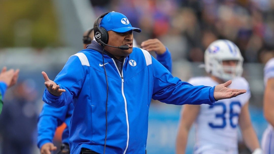 BYU head coach Kalani Sitake talks with his players after a Boise State touchdown in the first half of an NCAA college football game, Saturday, Nov. 5, 2022, in Boise, Idaho. BYU won 31-28. (AP Photo/Steve Conner)