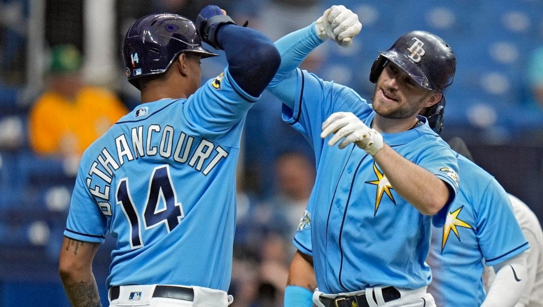 Tampa Bay Rays' Brandon Lowe celebrates his grand slam off Oakland Athletics starting pitcher James Kaprielian with Christian Bethancourt (14) during the fourth inning of a baseball game Sunday, April 9, 2023, in St. Petersburg, Fla.