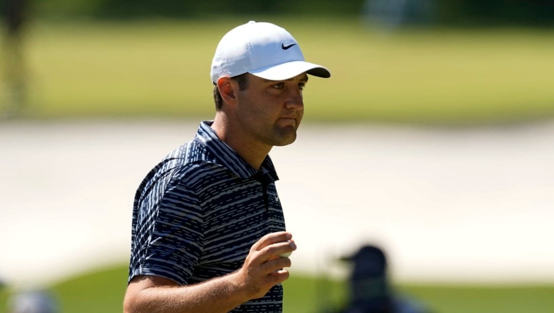 Scottie Scheffler holds up his ball after chipping in for birdie on the third hole during the final round at the Masters golf tournament on Sunday, April 10, 2022, in Augusta, Ga.